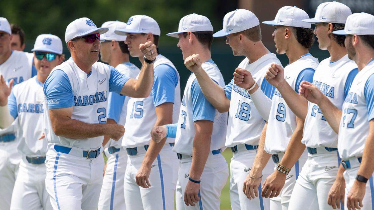 North Carolina coach Scott Forbes fist bumps his players as he is introduced prior to the Tar Heels game against Arkansas on Saturday, June 11, 2022 at Boshamer Stadium in Chapel Hill, N.C.