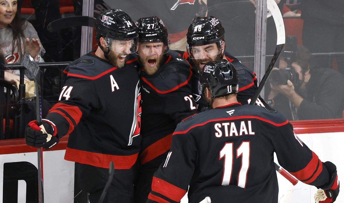 Carolina's Jaccob Slavin (74), Jordan Martinook (48), and Jordan Staal (11) celebrate with Nikolaj Ehlers (27) after he scored in the second period of the Hurricanes’ game against the Canadiens in game two of the Eastern Conference Finals at the Lenovo Center in Raleigh, N.C., Saturday, May 23, 2026.