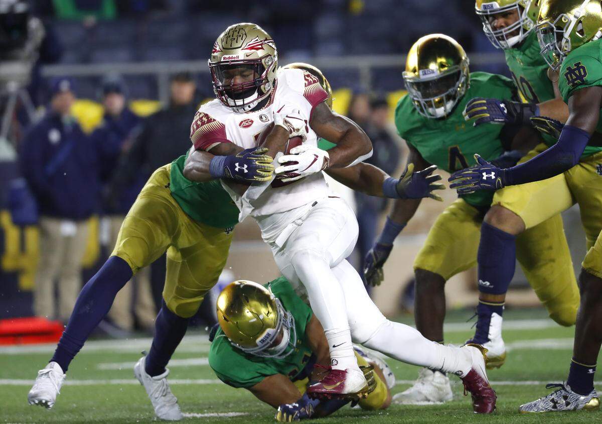 Florida State running back Cam Akers (3) pulls Notre Dame defensive lineman Julian Okwara (42) into the end zone for a rushing touchdown in the second half of an NCAA college football game in South Bend, Ind.,Saturday, Nov. 10, 2018.