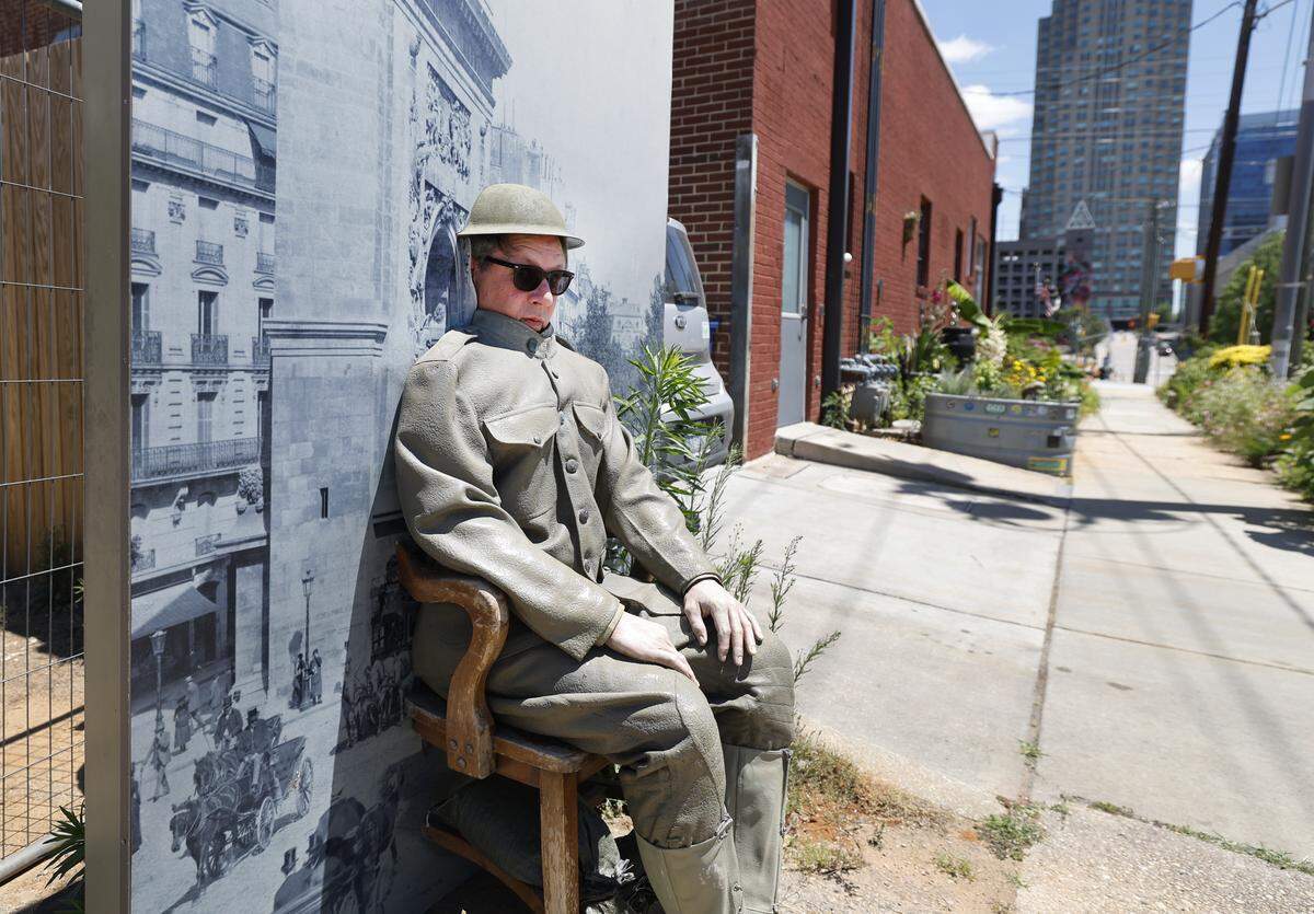 Josh Shaffer poses with the World War I soldier display on West Cabarrus St. near S. Dawson St. in Raleigh. The display came from the N.C. Museum of History, which is being renovated.