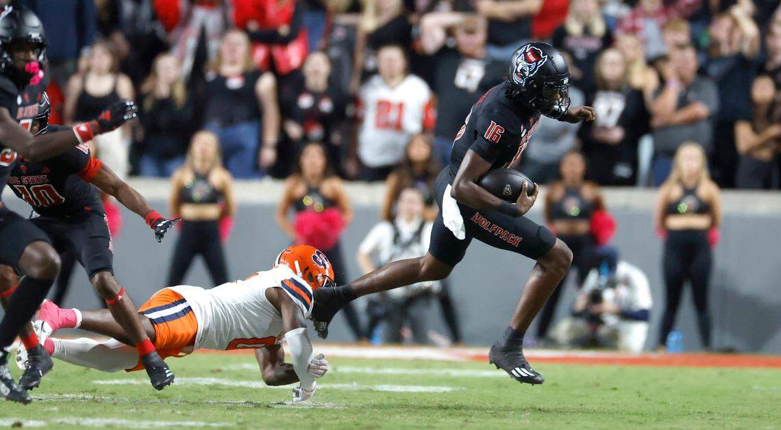 N.C. State quarterback CJ Bailey (16) escapes from Syracuse defensive back Duce Chestnut (0) during the first half of N.C. State’s game against Syracuse at Carter-Finley Stadium in Raleigh, N.C., Saturday, Oct. 12, 2024.