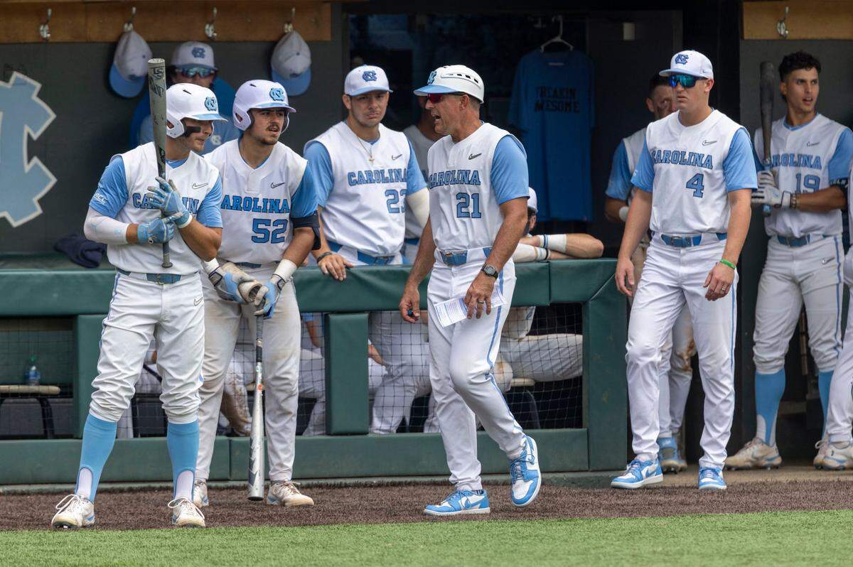 North Carolina coach Scott Forbes (21) talks with batters Mikey Madej (2) and Tomas Frick (52) in the bottom of the ninth inning against Arkansas, during the first game of their Super Regional series on Saturday, June 11, 2022 at Boshamer Stadium in Chapel Hill, N.C. Arkansas defeated North Carolina 4-1.