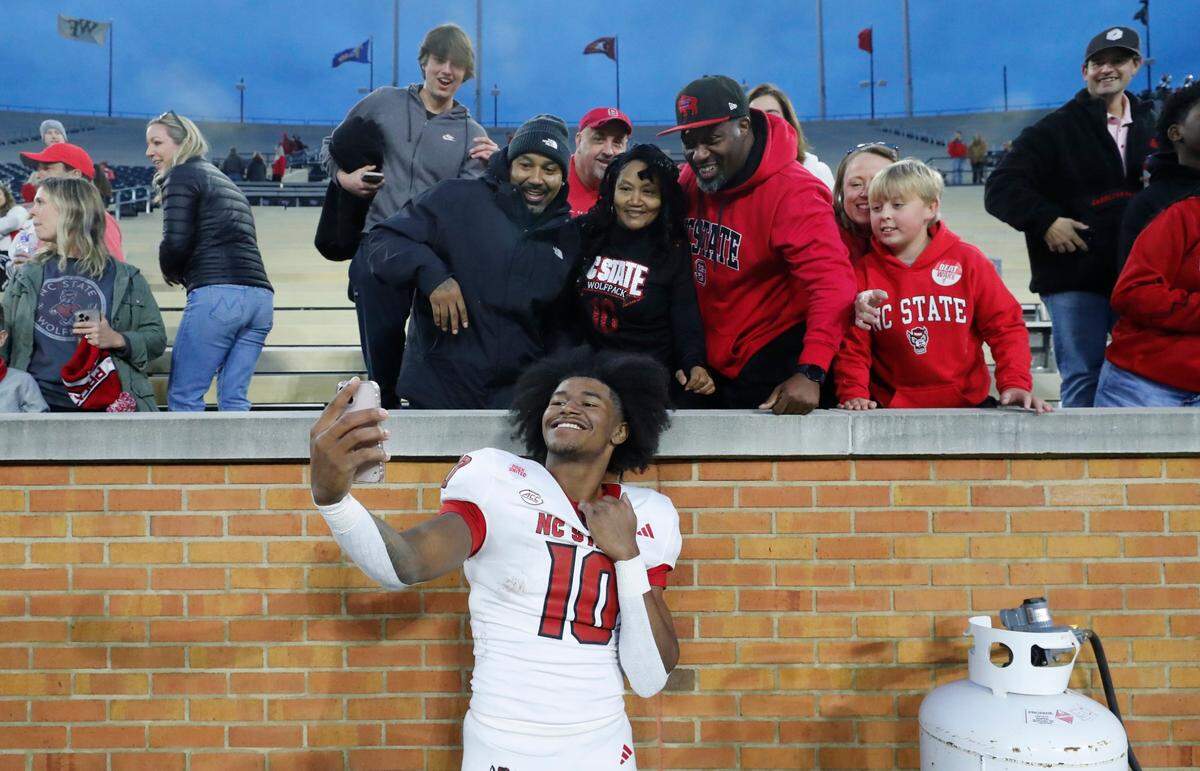 N.C. State’s KC Concepcion (10) takes photos with fans after the Wolfpack’s 26-6 victory over Wake Forest at Allegacy Stadium in Winston-Salem, N.C., Saturday, Nov. 11, 2023.