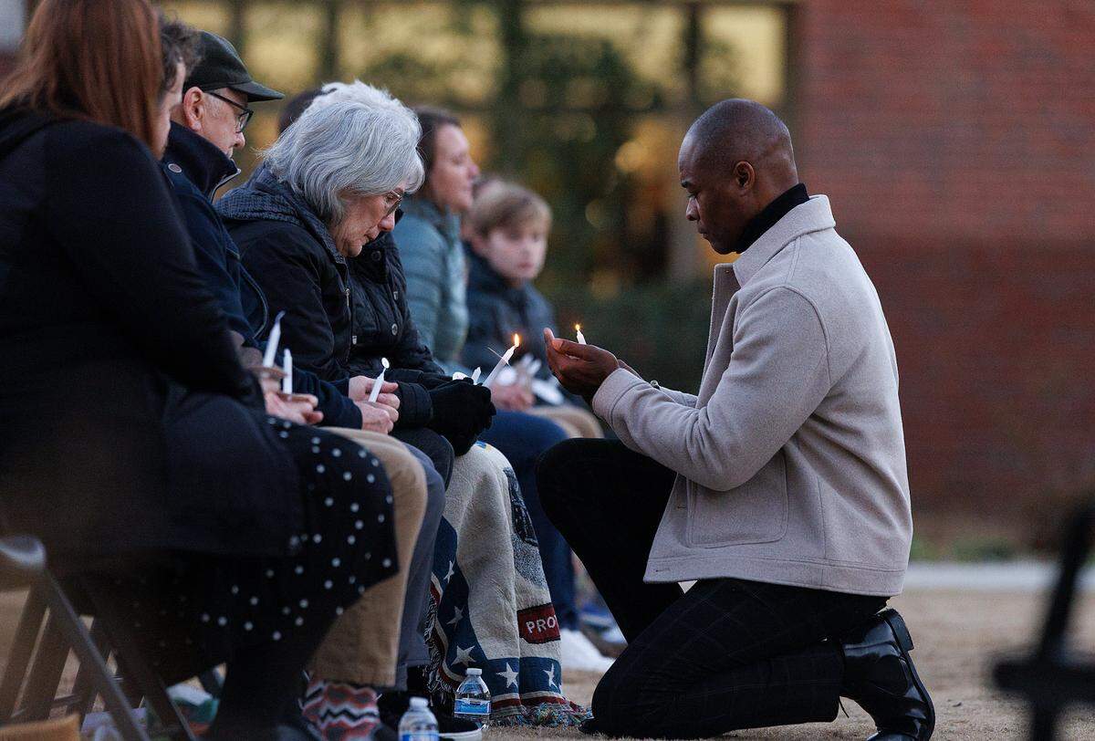 Apex Mayor Jacques Gilbert helps to light candles during a vigil held outside the Apex Town Hall on Monday, Jan. 29, 2024, to honor Nancy Taylor and Gabrielle Raymond, who were shot and killed in an Apex neighborhood on Jan. 15.