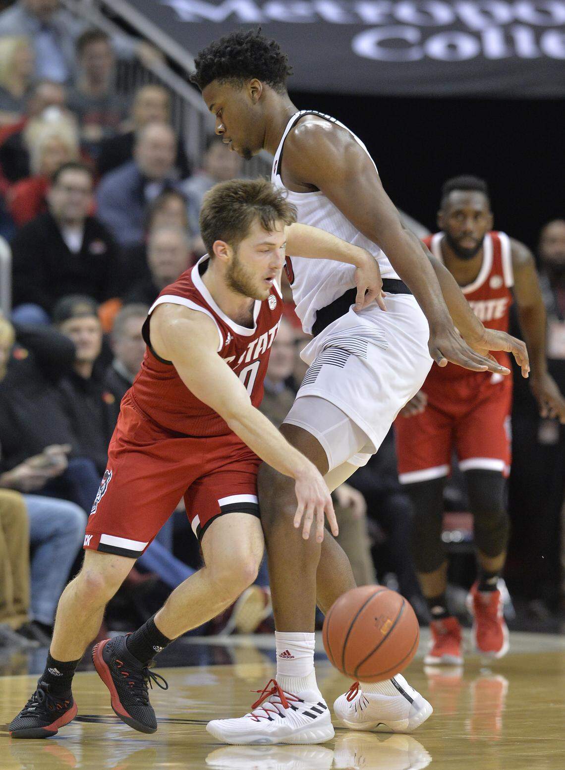 North Carolina State guard Braxton Beverly (10) makes his way around Louisville center Steven Enoch (23) during the second half of an NCAA college basketball game in Louisville, Ky., Thursday, Jan. 24, 2019. Louisville won 84-77.