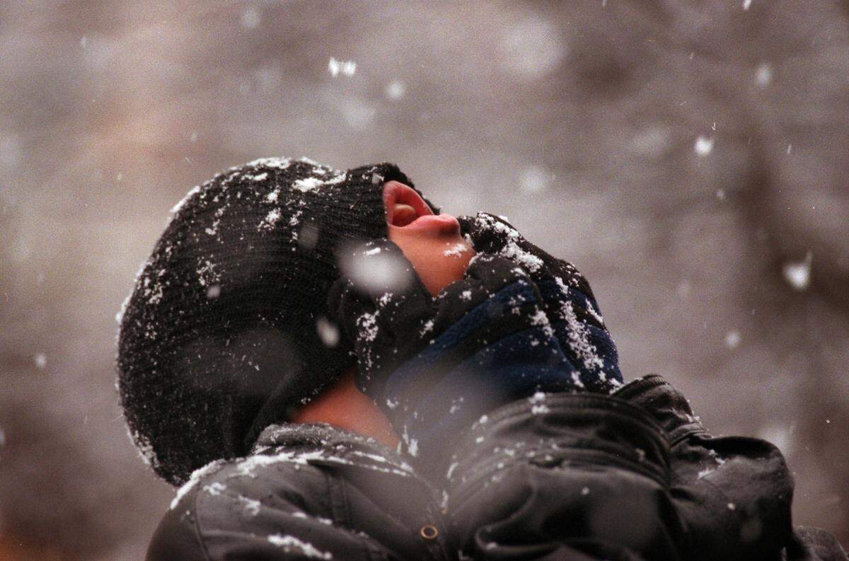 With his toboggan pulled down over his face, Evan Thompson tries to catch some of Monday’s large snowflakes in his mouth in 1998.