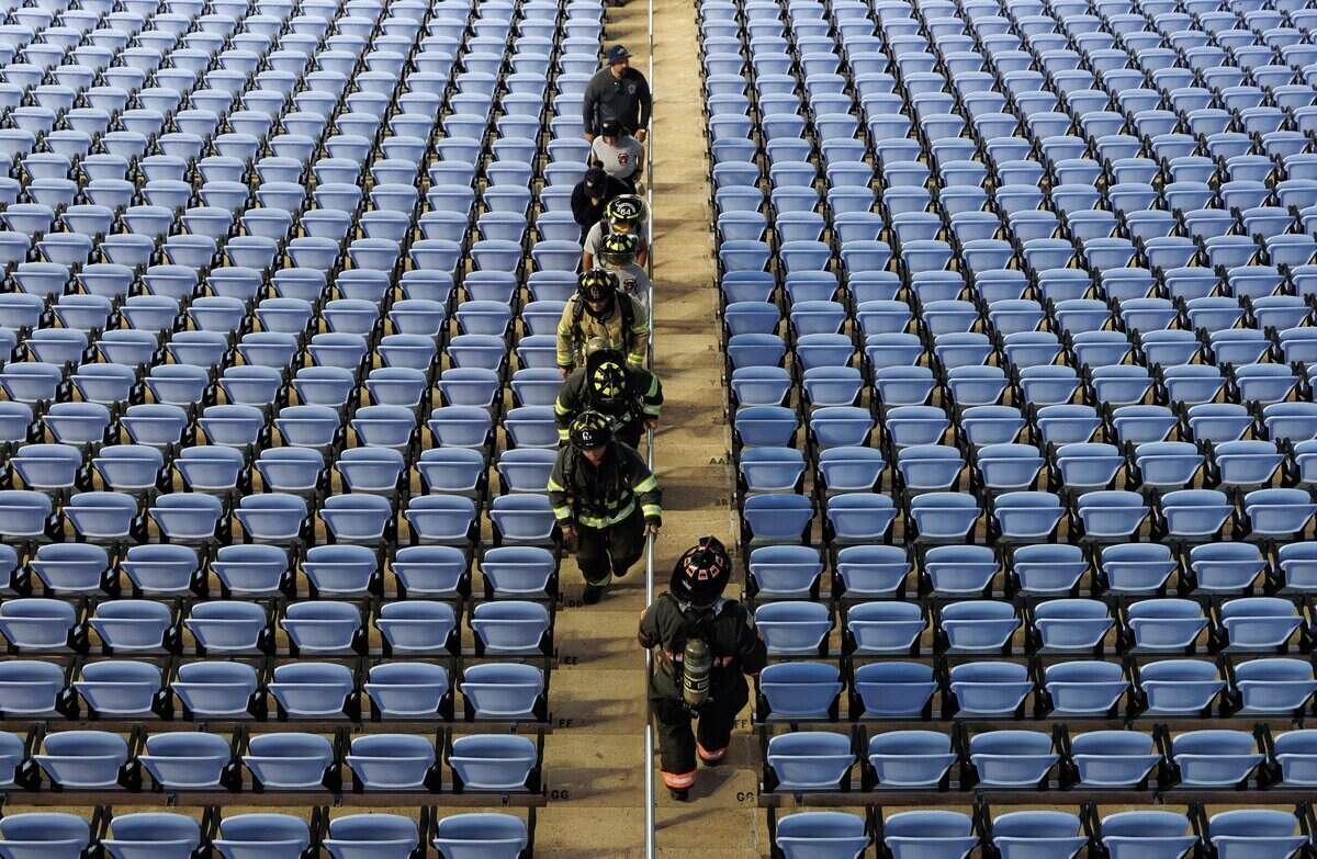 Participants climb the stairs amid a sea of blue seats at Kenan Memorial Stadium during an event in Chapel Hill, N.C. on Thursday, Sept. 11, 2025, to honor those who lost their lives during attacks of Sept. 11, 2001.
