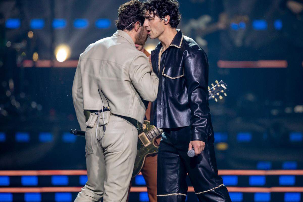 Nick and Joe Jonas greet each other as they take the stage with their brother Kevin during their “Five Albums, One Night” tour stop at the PNC Arena on Thursday, September 28, 2023 in Raleigh, N.C