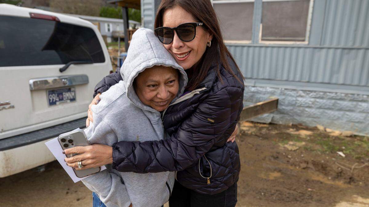 Yolanda Adams, co-founder of Q’Pasa Appalachia, hugs Zenaida Hernandez, after giving her a gift card to help purchase a new stove for her flooded mobile home on Wednesday, November 27, 2024 in Boone, N.C.