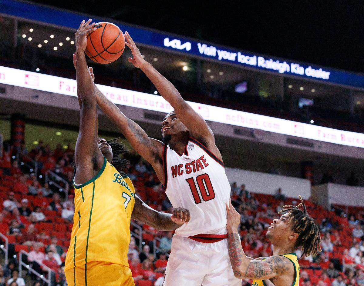 N.C. State’s Marcus Hill, Jr. is pressured by Lees-McRae’s Anthony Parker and Dre Jackson during the first half of the Wolfpack’s 79-75 exhibition win on Wednesday, Oct. 30, 2024, at the Lenovo Center.