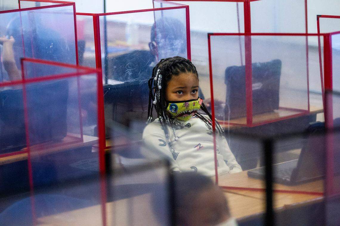 A student sits behind a clear partition during a first-grade class lesson at Mariam Boyd Elementary in Warrenton Tuesday, Dec. 7, 2021. Rural North Carolina school systems like Warren County Public Schools have been waiting since the start of the Leandro court case in 1994 to get the funding needed to level the playing field with urban districts.