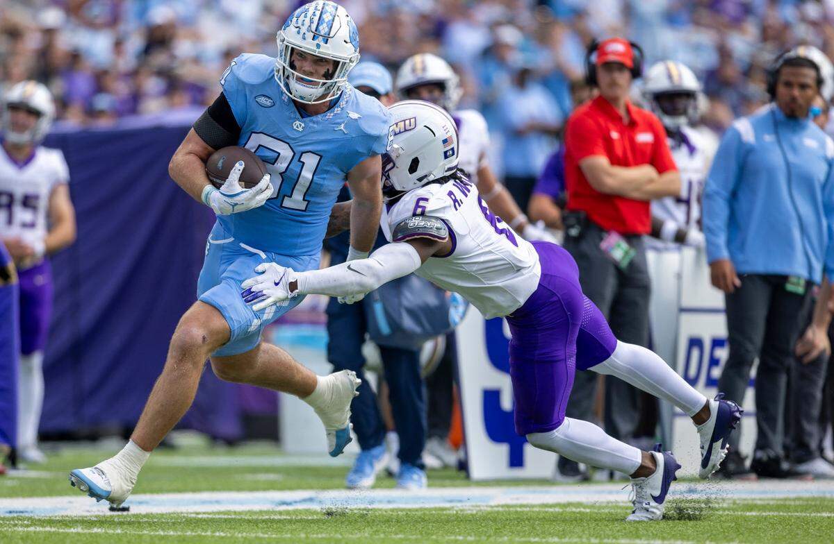 North Carolina tight end John Copenhaver (81) scores a touchdown on a 35-yard pass reception from quarterback Jacolby Criswell (12) ahead of James Madison defensive back Ray Williams (6) in the first quarter on Saturday, September 21, 2024 at Kenan Stadium in Chapel Hill, N.C.