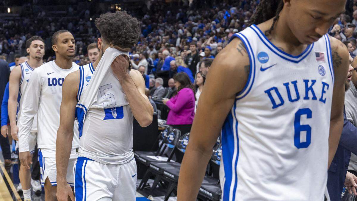 Duke guard Cayden Boozer (2) covers his face as he leaves the court with his teammates after falling to Connecticut 73-72 on Sunday, March 29, 2026, in the NCAA East Regional Championship, at Capital One Arena in Washington, D.C