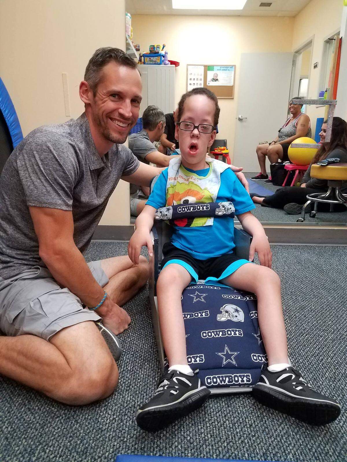 Gabrial Smith at age 5, with physical therapist Brian Gentry, when Gabrial first got his custom made floor sitter from Made4M3.
