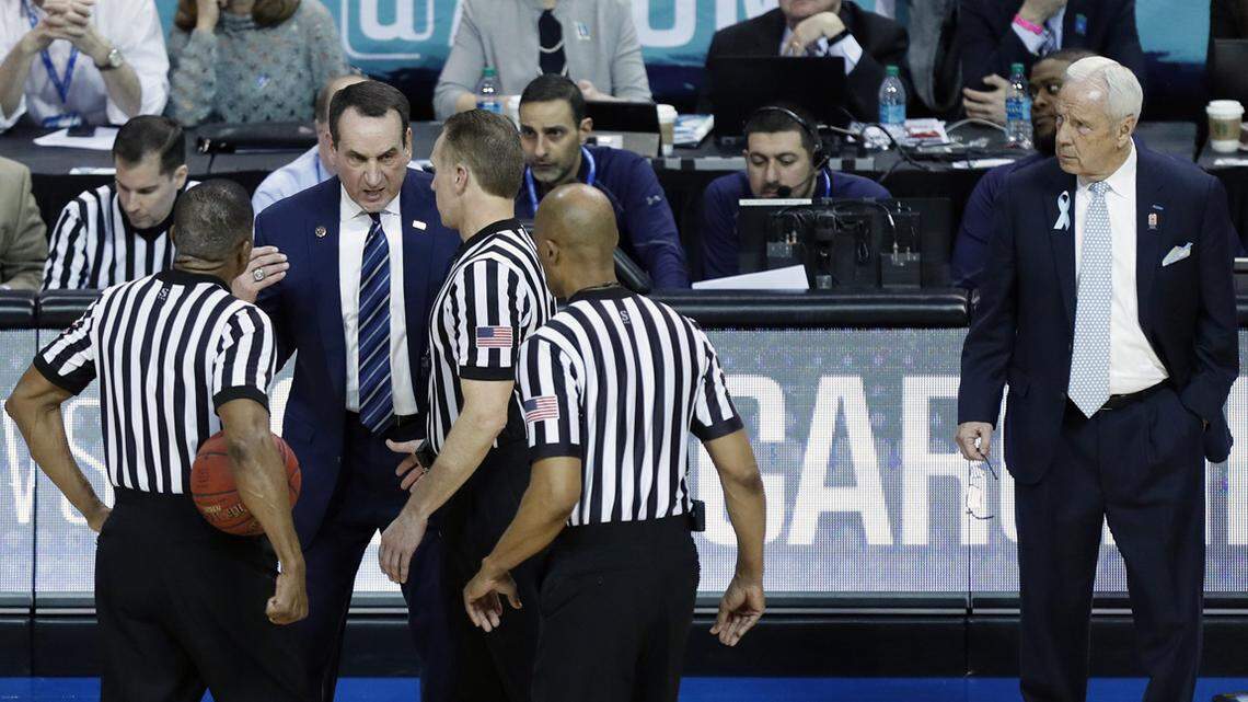 Duke head coach Mike Krzyzewski argues the foul against Grayson Allen with the officials as North Carolina head coach Roy Williams looks on during the first half.