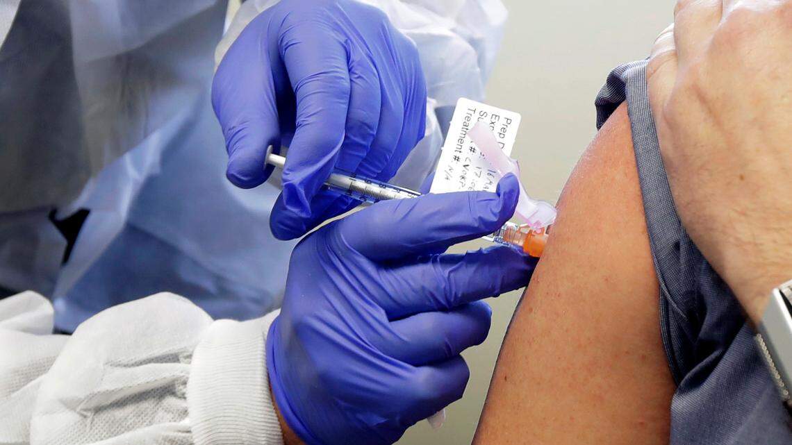 In this March 16, 2020, file photo, Neal Browning receives a shot at the Kaiser Permanente Washington Health Research Institute in Seattle, in the first-stage safety study clinical trial of a potential vaccine for COVID-19, the disease caused by the coronavirus.