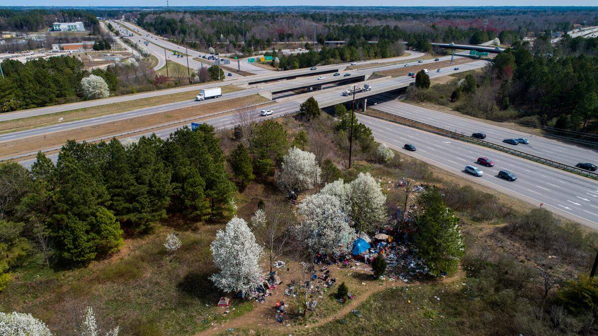 An aerial view of a camp between Interstate 540 and an exit ramp to Capital Boulevard as it appeared in March 2021. After years of complaints, the N.C. Department of Transportation recently cleared the site of trash and debris.