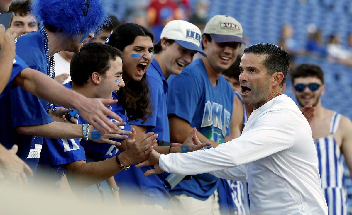 Duke head coach Manny Diaz high fives students prior to the Blue Devils’ season opener against Elon on Thursday, Aug. 28, 2025, at Wallace Wade Stadium in Durham, N.C.
