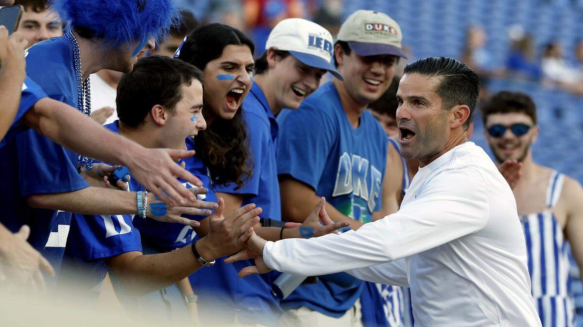 Duke head coach Manny Diaz high fives students prior to the Blue Devils’ season opener against Elon on Thursday, Aug. 28, 2025, at Wallace Wade Stadium in Durham, N.C.