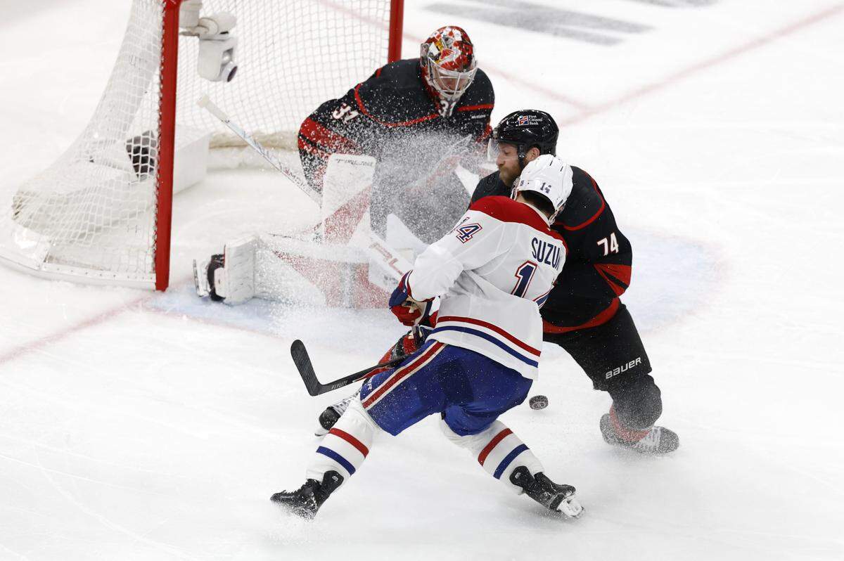 Carolina's Jaccob Slavin (74) defends Montréal's Nick Suzuki (14) as Frederik Andersen (31) watches the puck during the second period of the Hurricanes’ game against the Canadiens in game one of the Eastern Conference Finals at the Lenovo Center Thursday, May, 21, 2026.