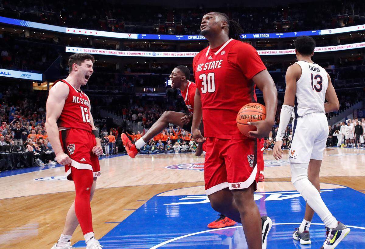 N.C. State’s Michael O’Connell (12) and Mohamed Diarra (23) celebrate with DJ Burns Jr. (30) after Burns made the basket while being fouled in overtime during N.C. State’s 72-65 overtime victory over Virginia in the semifinals of the 2024 ACC Men’s Basketball Tournament at Capital One Arena in Washington, D.C., Friday, March 15, 2024.