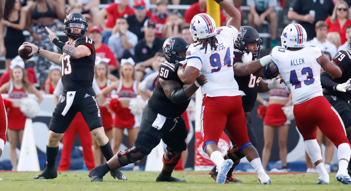N.C. State’s Chandler Zavala (64), right, and Grant Gibson (50) provide protection for quarterback Devin Leary (13) during the Wolfpack’s game against Louisiana Tech at Carter-Finley Stadium in Raleigh, N.C., Saturday, October 2, 2021.