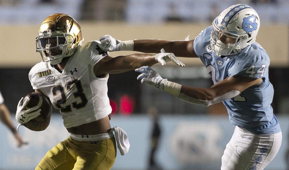 Notre Dame’s Kyren Williams (23) rushes past North Carolina’s Jeremiah Gemmell (44) for a gain of 11 yards in the fourth quarter on Friday, November 27, 2020 at Kenan Stadium in Chapel Hill, N.C. Williams rushed for 124 yards and two touchdown in Notre Dame’s 31-17 victory.