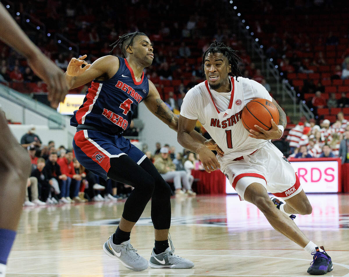 N.C. State’s Jayden Taylor drives past Detroit’s Marcus Tankersley during the second half of the Wolfpack’s 83-66 win on Saturday, Dec. 23, 2023, at PNC Arena in Raleigh, N.C.