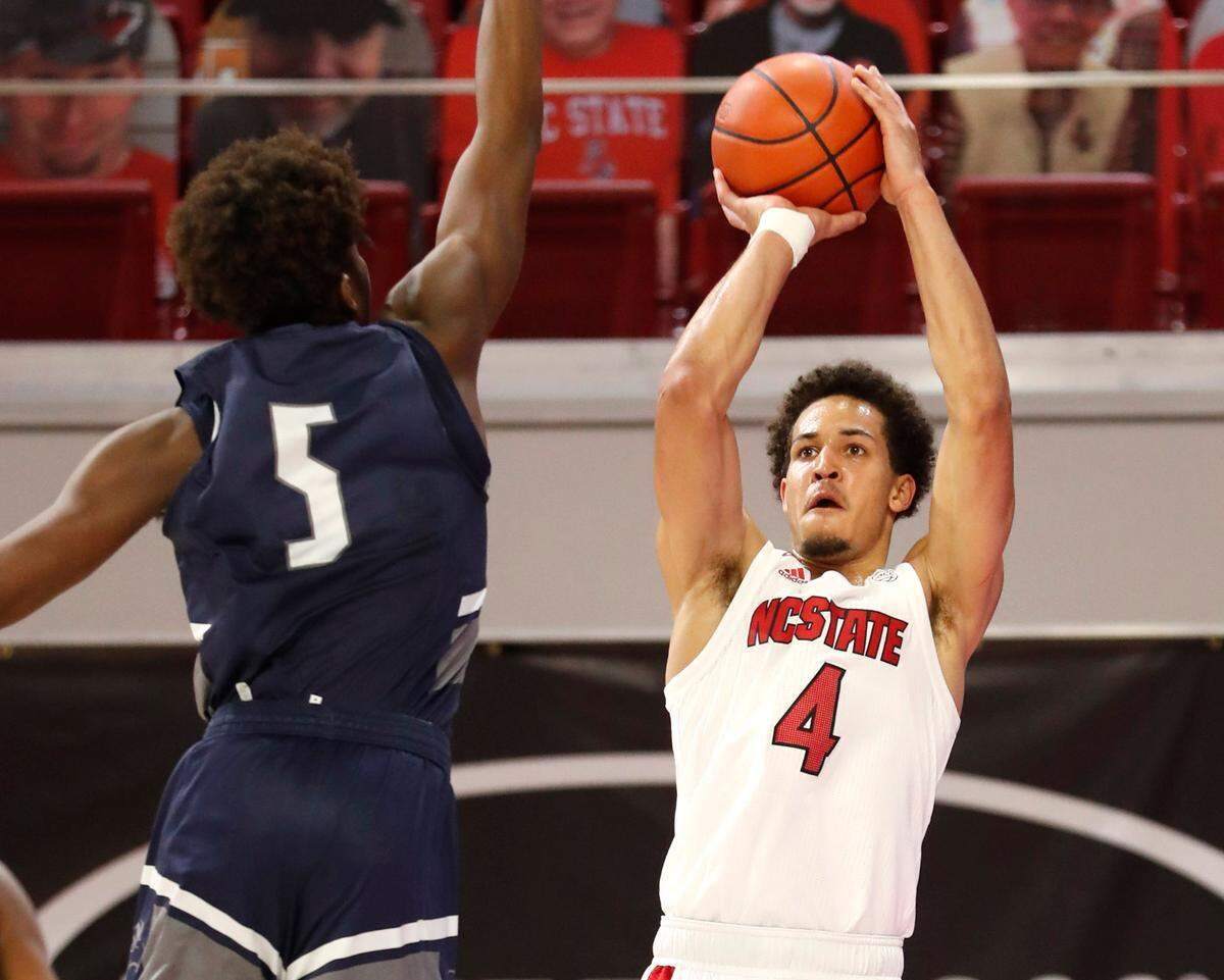 N.C. State’s Jericole Hellems (4) shoots as North Florida’s Dorian James (5) defends during the first half of N.C. State’s game against North Florida in the Mako Medical Wolfpack Invitational at Reynolds Coliseum in Raleigh, N.C., Friday, Nov. 27, 2020.