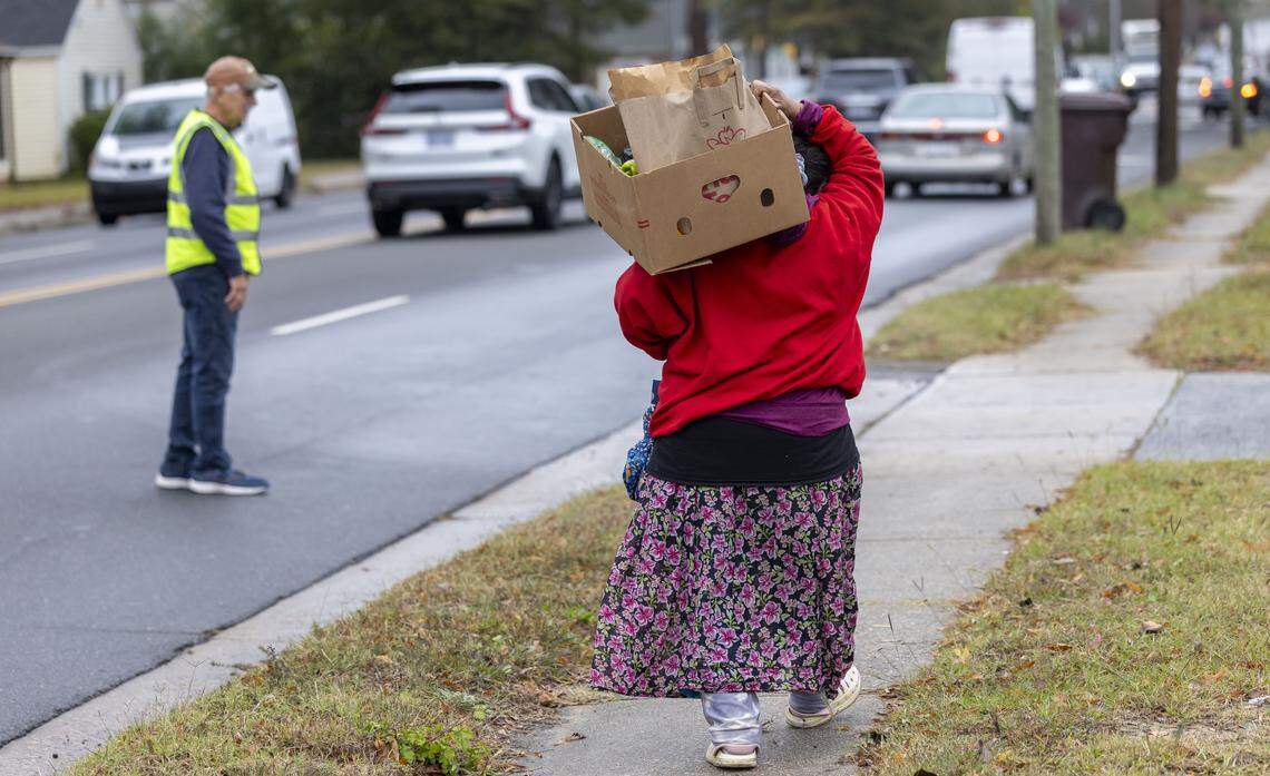 A recipient of the Emanuel Food Pantry at Durham Presbyterian Church, walks home with a box of groceries after visiting the weekly pantry on Roxboro Street on Wednesday, October 29, 2025 in Durham, N.C.