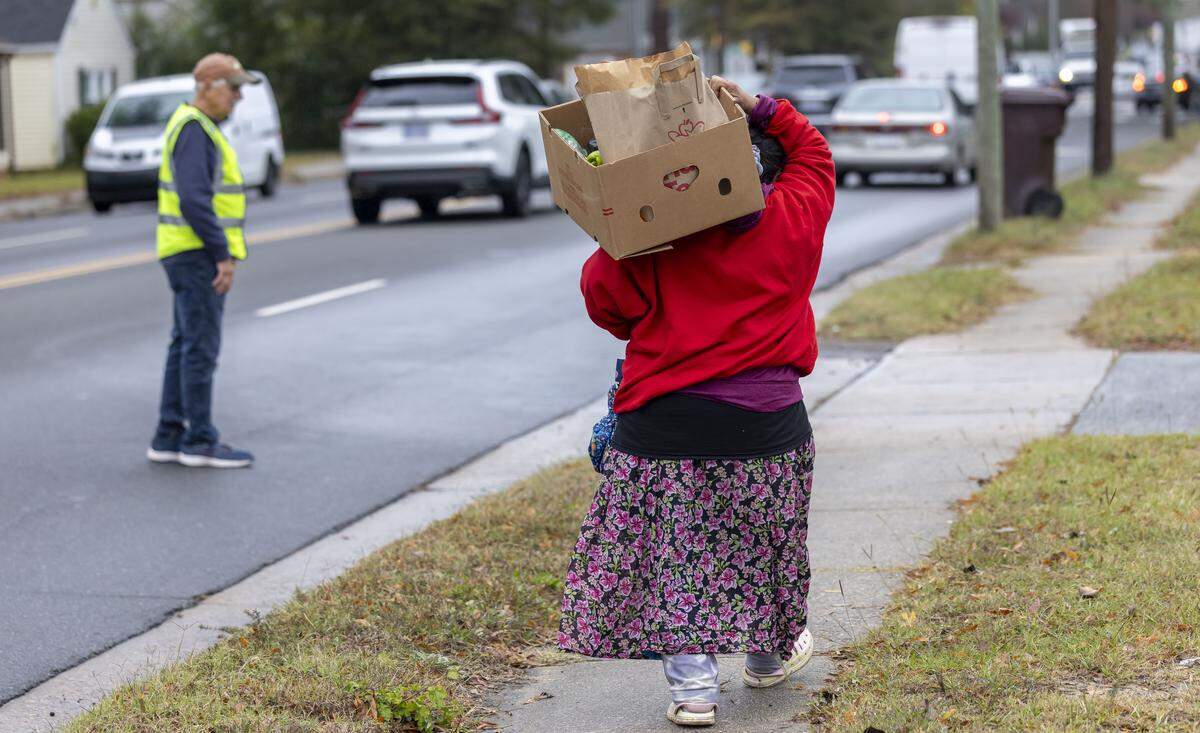 A recipient of the Emanuel Food Pantry at Durham Presbyterian Church, walks home with a box of groceries after visiting the weekly pantry on Roxboro Street on Wednesday, October 29, 2025 in Durham, N.C.