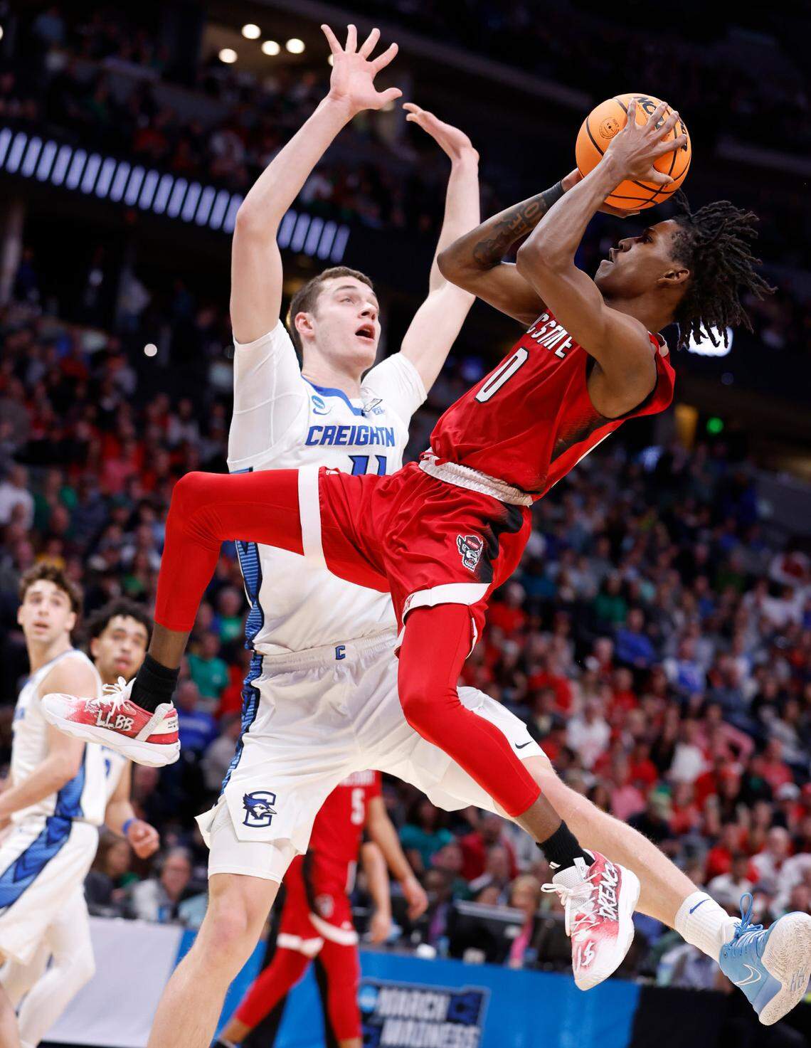 N.C. State’s Terquavion Smith (0) shoots as Creighton’s Ryan Kalkbrenner (11) defends during the first half of N.C. State’s game against Creighton in the first round of the NCAA Tournament at Ball Arena in Denver, Colo., Friday, March 17, 2023.
