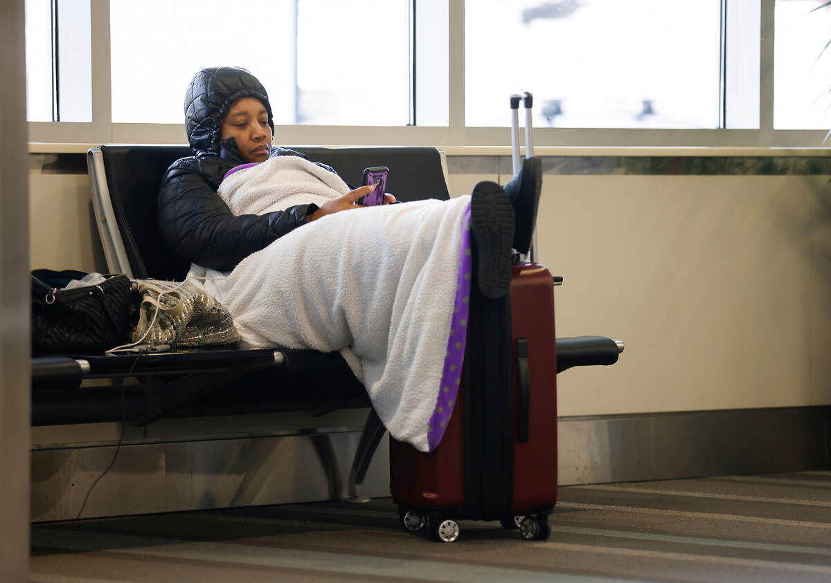 Carolyn Branch waits in Terminal 1 at Raleigh-Durham International Airport for her family to give her a ride to Charlotte after her flight was cancelled on Tuesday, Dec. 27, 2022.