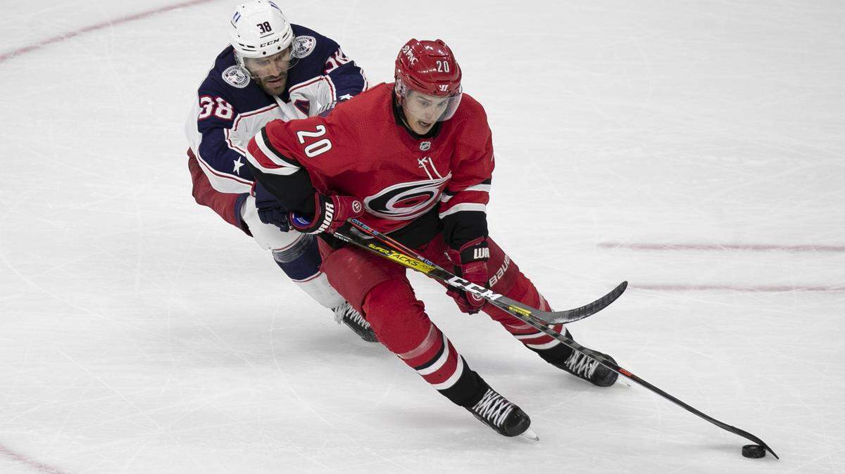 Carolina Hurricanesí Sebastian Aho (20) controls the puck against Columbusí Boone Jenner (38) during an overtime period on Saturday, March 20, 2021 at PNC Arena in Raleigh, N.C.