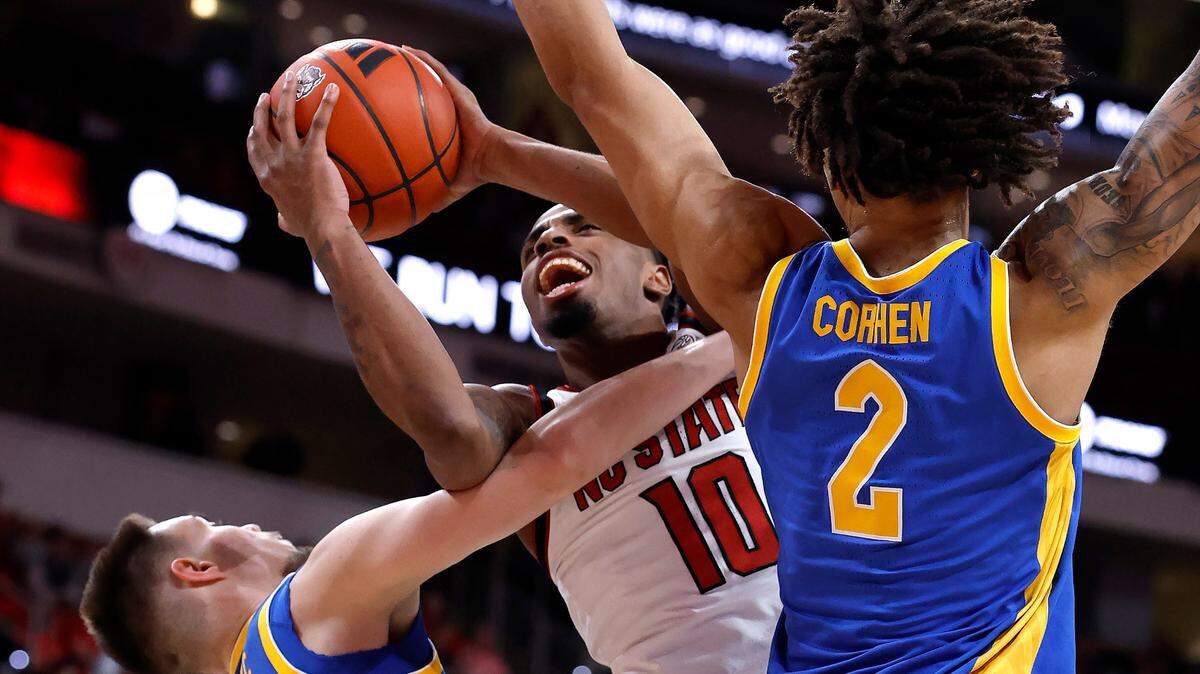 N.C. State’s Marcus Hill (10) is fouled as he drives to the basket between Pittsburgh’s Amsal Delalic (52) and Cameron Corhen (2) during the first half of N.C. State’s game against Pitt at the Lenovo Center in Raleigh, N.C., Wednesday, March 5, 2025.