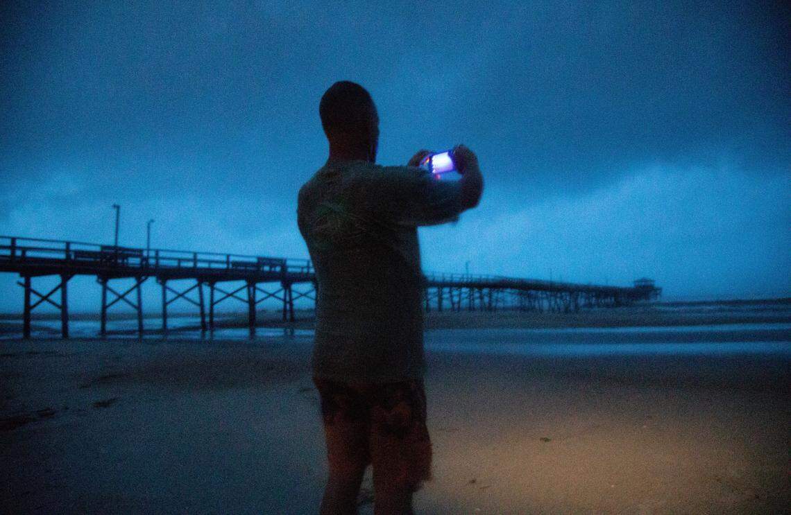Mike Perry, 49, of Morehead City takes photos before sunrise near the Oceanana Pier & Pier House Restaurant in Atlantic Beach Thursday, Sept. 13, 2018 as Hurricane Florence approaches the Carolinas.