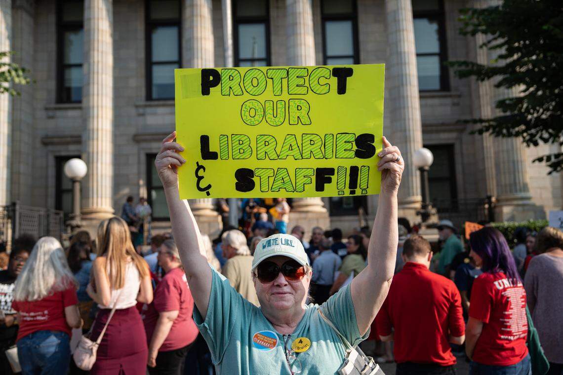 Jean Hendrick stands for a portrait with her sign during the rally outside the Alamance County Courthouse in Graham, N.C. on June 2, 2025. People gathered to protest budget cuts to the library system and its social services.
