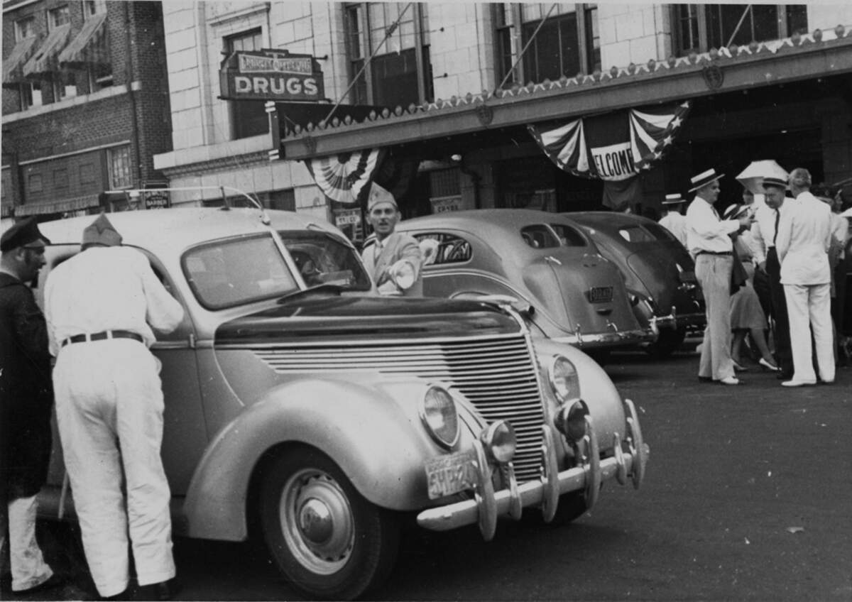 A scene from the American Legion parade, Fayetteville Street, Morgan Street, Raleigh, NC, August, 1939. The car in the foreground is a 1938 Ford Standard