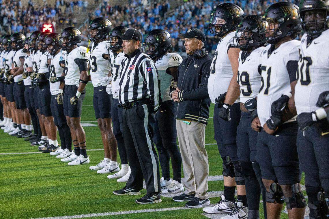 Wake Forest coach Dave Clawson stands with his players during the coin toss at the beginning of their game against North Carolina on Saturday, November 16, 2024 at Kenan Stadium in Chapel Hill, N.C.