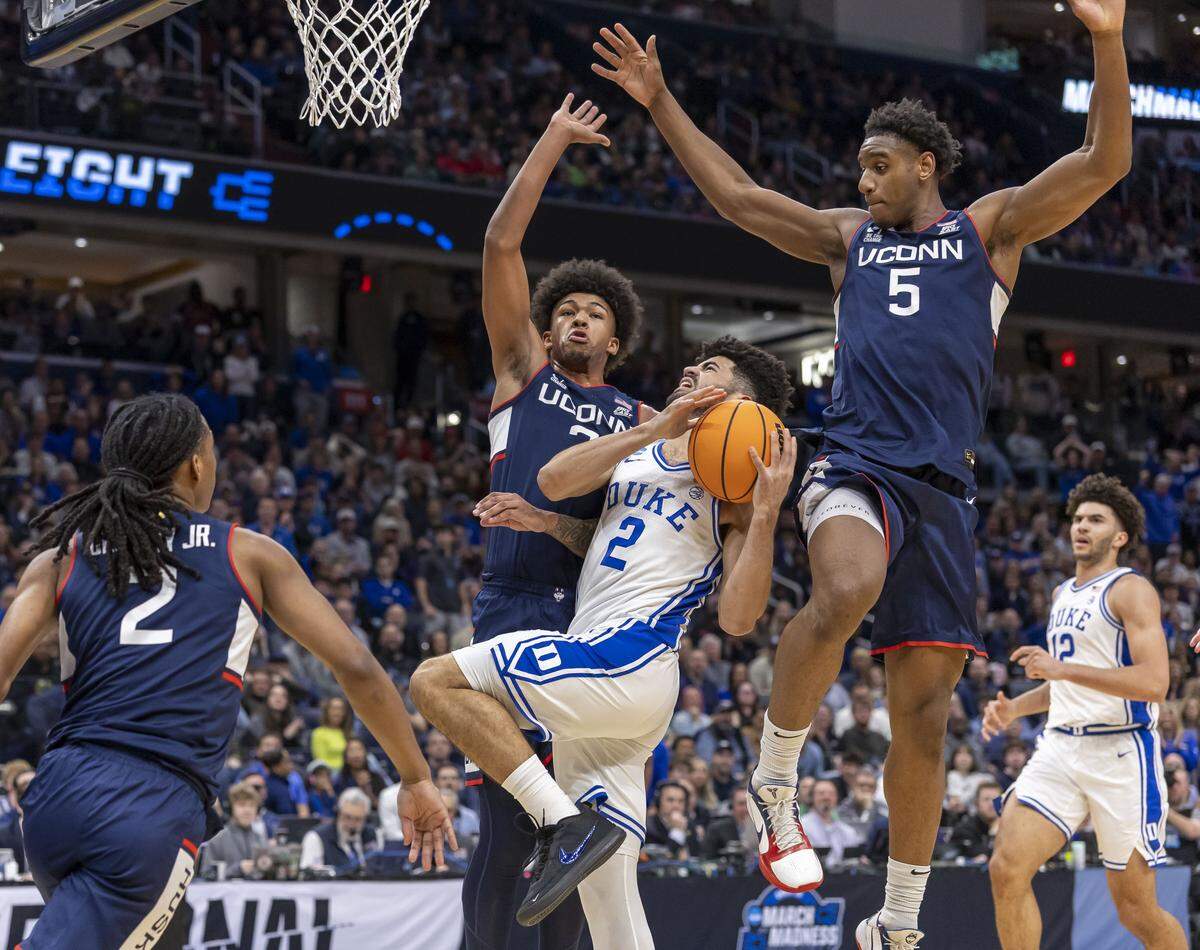 Connecticut forwards Jaylin Stewart (3) and Tarris Reed Jr. (5) defend Duke guard Cayden Boozer (2) in the first half on Sunday, March 29, 2026, in the NCAA East Regional Championship, at Capital One Arena in Washington, D.C.