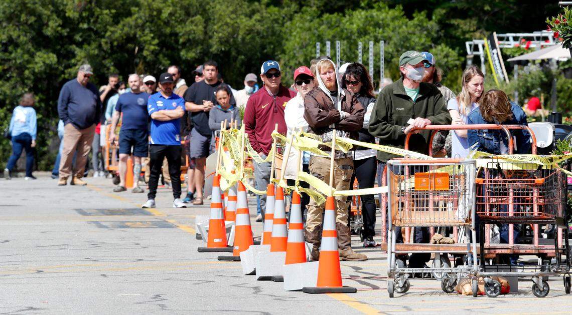 Shoppers line up to enter The Home Depot in Fuquay-Varina, N.C., Friday, April 10, 2020.