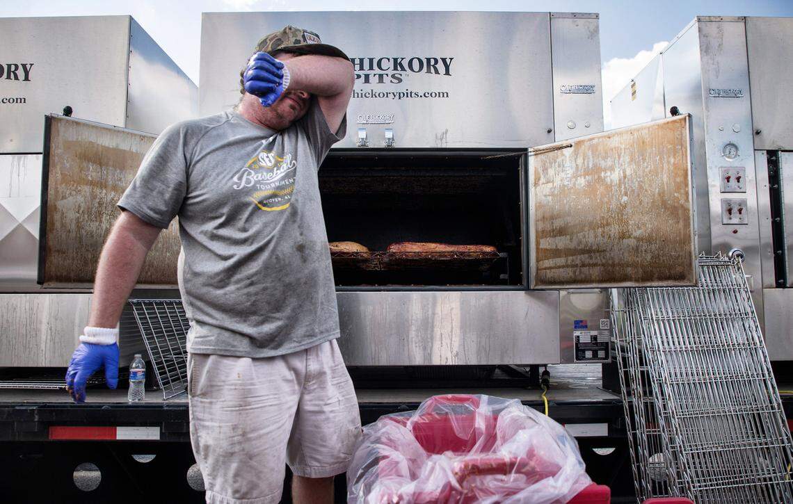 Nick Woolfolk, a volunteer from Mississippi, wipes away sweat before prepping smoked pork for Operation BBQ Relief’s dinner shift on Wednesday, Sept. 19, 2018.