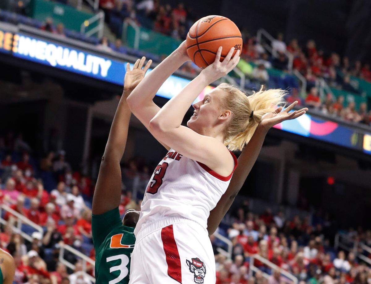 N.C. State’s Elissa Cunane (33) shoots while being fouled by Miami’s Maeva Djaldi-Tabdi (33) during the first half of N.C. State’s game against Miami in the championship of the ACC women’s basketball tournament in Greensboro, N.C., Sunday, March 6, 2022.