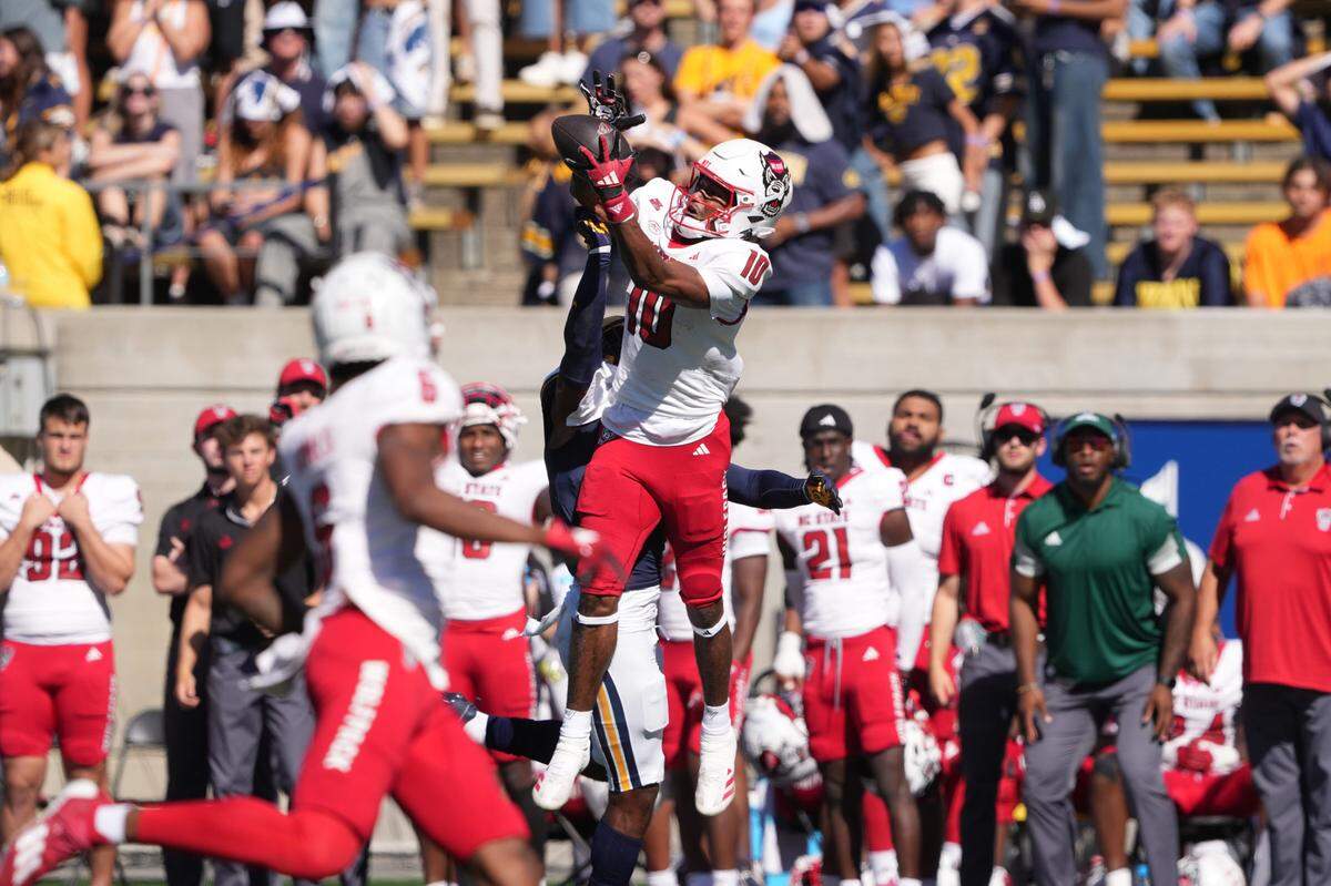 Oct 19, 2024; Berkeley, California, USA; North Carolina State Wolfpack wide receiver Kevin Concepcion (10) catches a pass against California Golden Bears defensive back Craig Woodson (center left) during the second quarter at California Memorial Stadium. Mandatory Credit: Darren Yamashita-Imagn Images