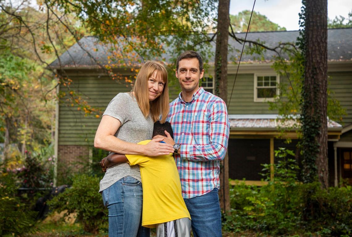 Brooks Rainey Pearson, left, and Dave Pearson stand for a portrait together with their foster son, on Tuesday, Oct. 27, 2020, in Durham, N.C.