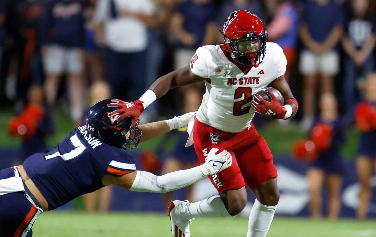 N.C. State running back Michael Allen (2) stiff-arms Virginia linebacker James Jackson (7) during the first half of N.C. State’s game against Virginia at Scott Stadium in Charlottesville, Va., Friday, Sept. 22, 2023.