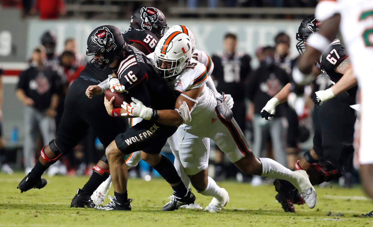 N.C. State quarterback Bailey Hockman (16) is sacked by Miami defensive lineman Jaelan Phillips (15) during the first half of N.C. State’s game against Miami at Carter-Finley Stadium in Raleigh, N.C., Friday, Nov. 6, 2020.