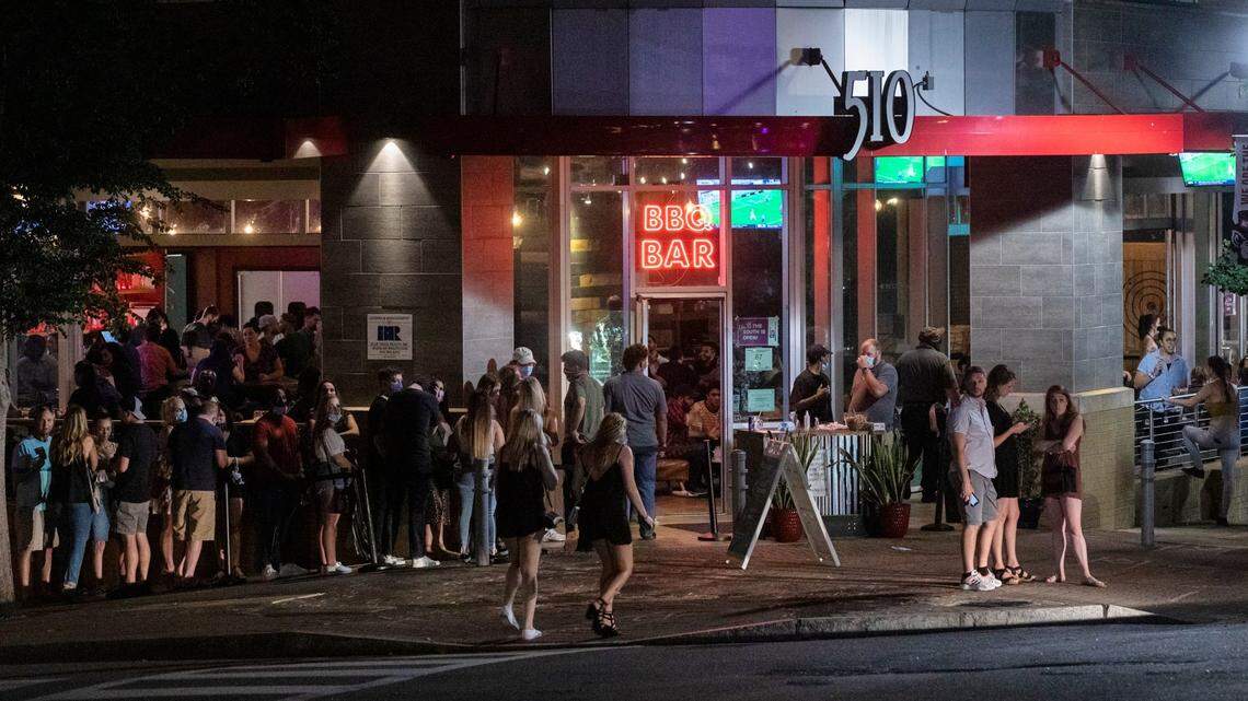 A line forms outside a restaurant on Glenwood Avenue, Southern Charred, which is allowed to operate with 50 percent capacity and safety measures to slow the spread of COVID-19 under Gov. Roy Cooper’s Phase Two of reopening that was extended as cases have climbed to their highest levels since the beginning of the pandemic, on Friday, Jun. 26, 2020, in Raleigh, N.C.