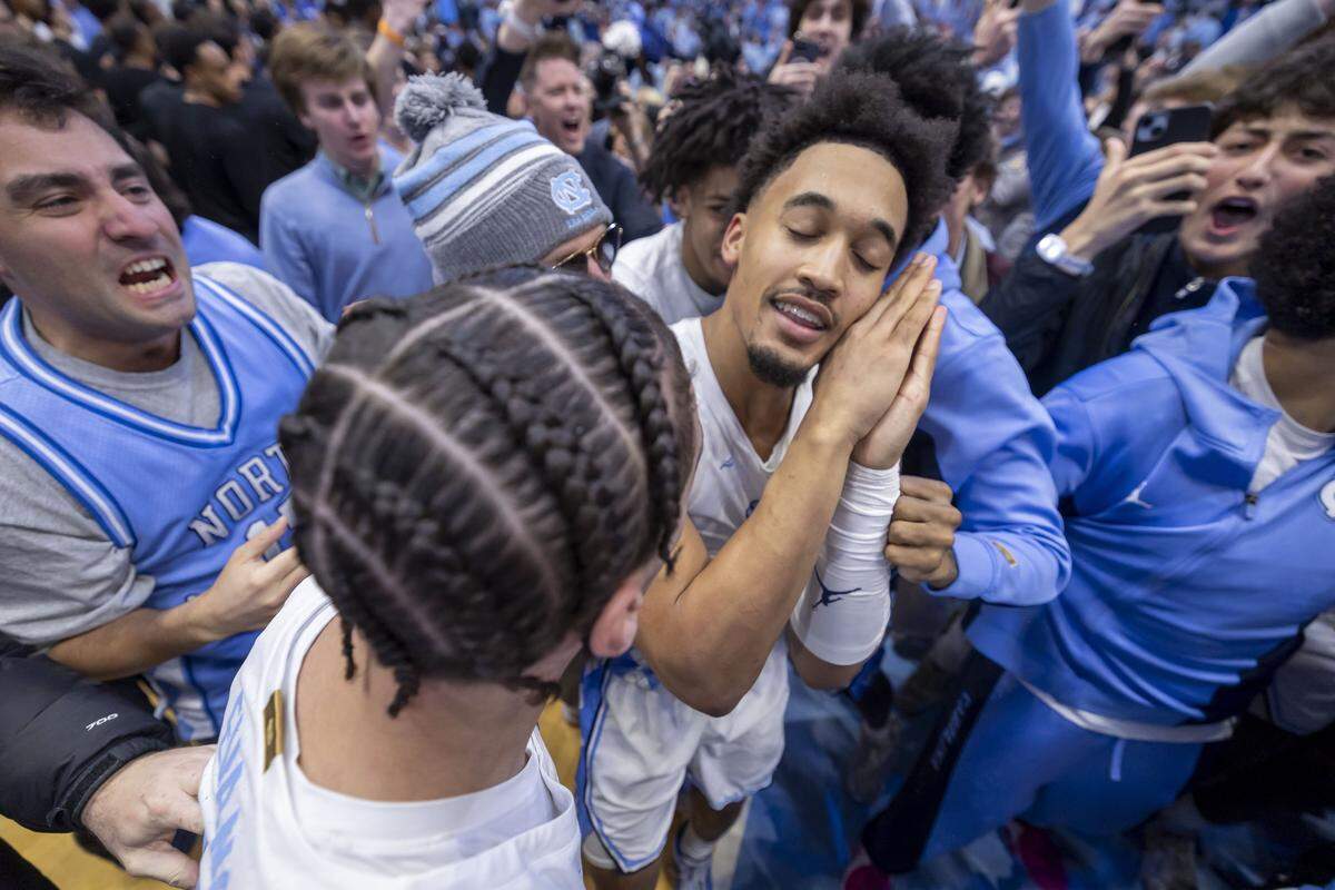 North Carolina guard Seth Trimble (7) reacts as fans storm the court, after sinking a three-point shot with .4 seconds to play, to give the Tar Heels a 71-68 victory over Duke on Saturday, February 7, 2026 at the Smith Center in Chapel Hill, N.C.