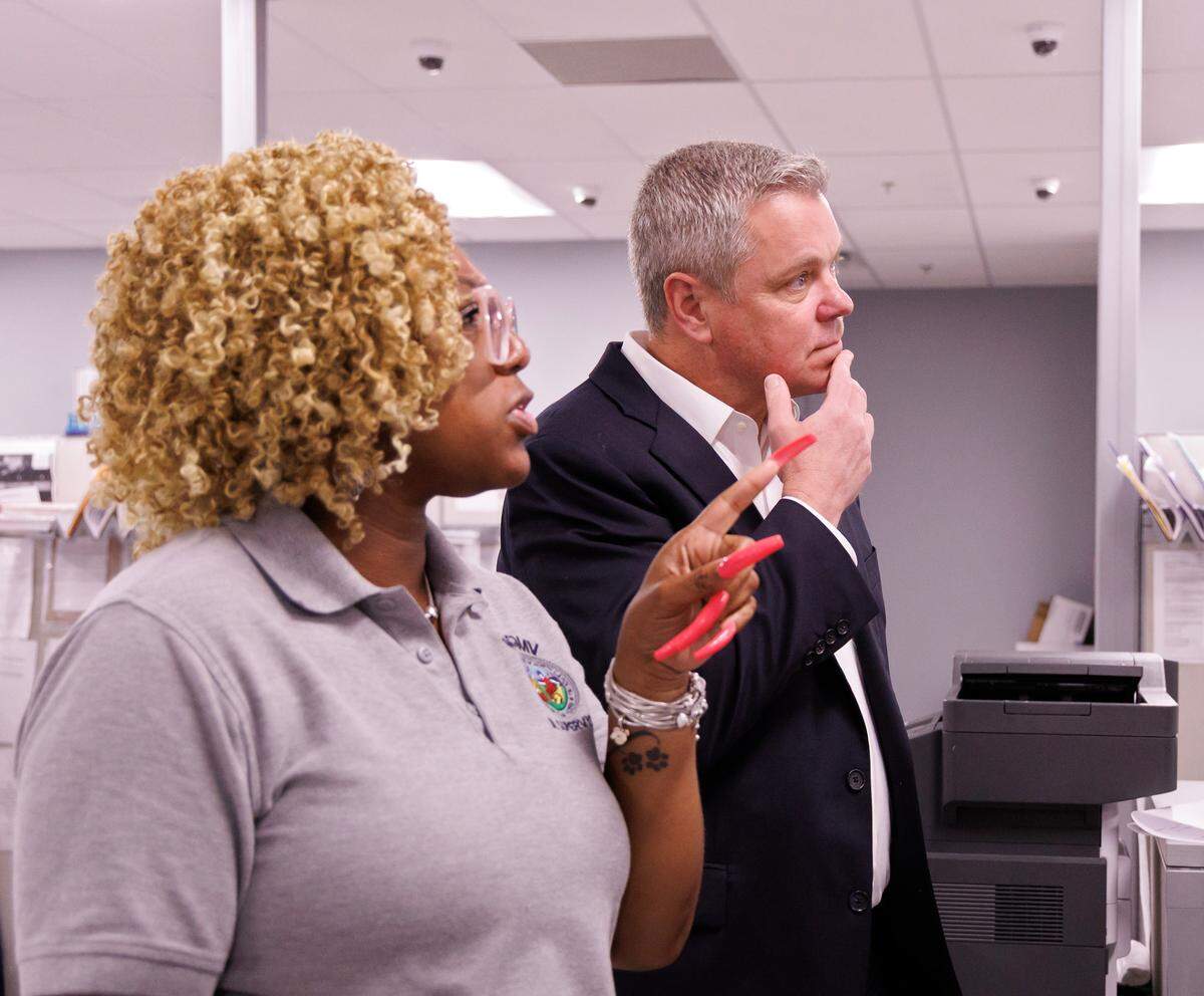 DMV Commissioner Paul Tine talks with Tanika Williams, a senior examiner at the East Raleigh office.